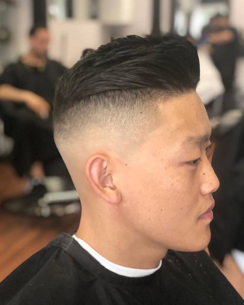 High skin fade with slicked-back textured top