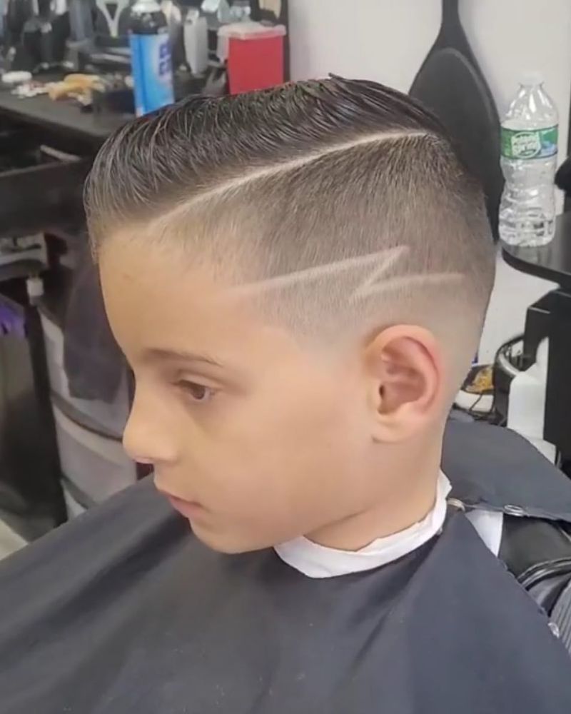Kid's side part with fade and lightning bolt design