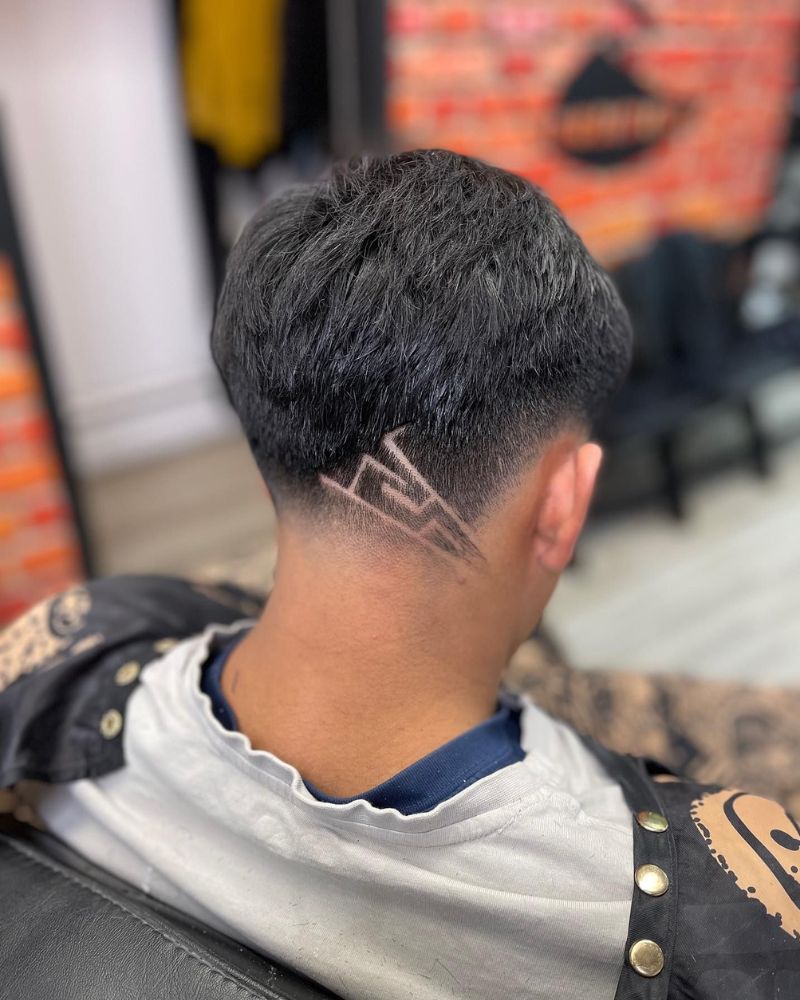 Back view of taper with geometric mountain design at nape
