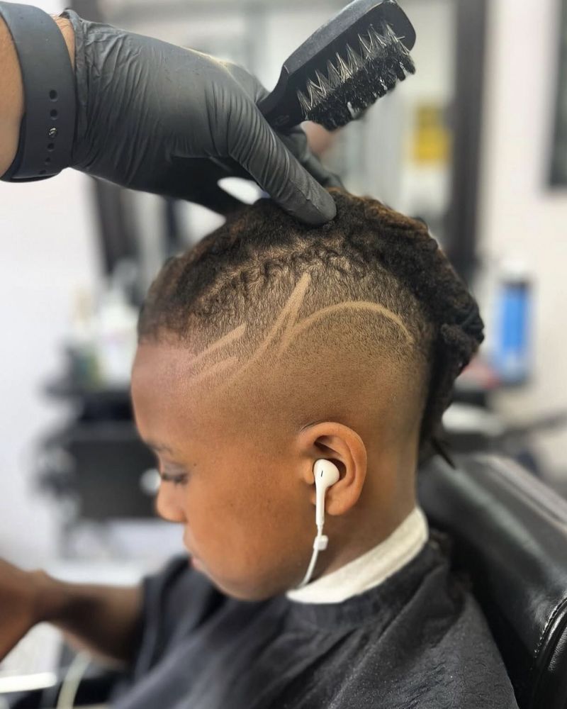 Kid's locs with carved star design lines on faded sides