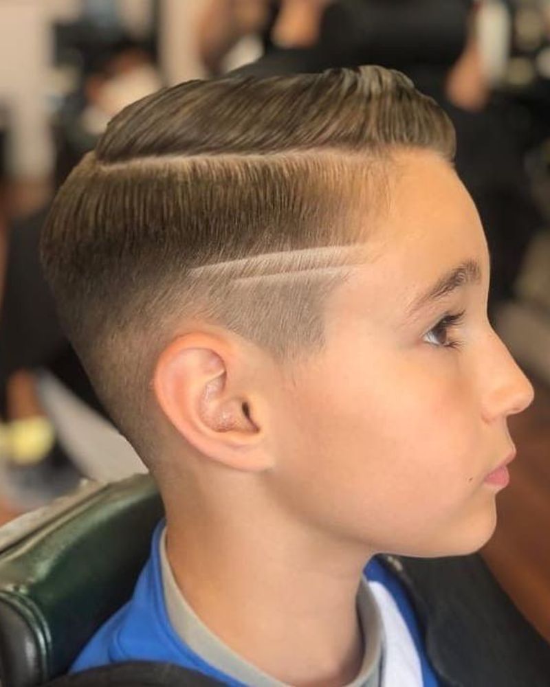 Kid's side-swept comb over with skin fade and line design
