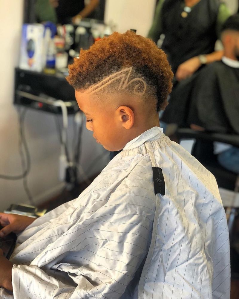 Kid's curly mohawk with carved wave design on faded sides