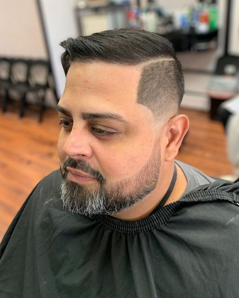 Classic comb-over with skin fade and sculpted full beard