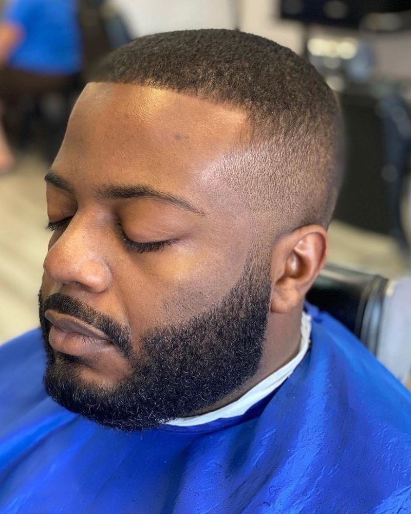 Low skin fade with shaped full beard